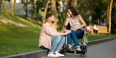 Man and woman with wheelchair sitting in the park
